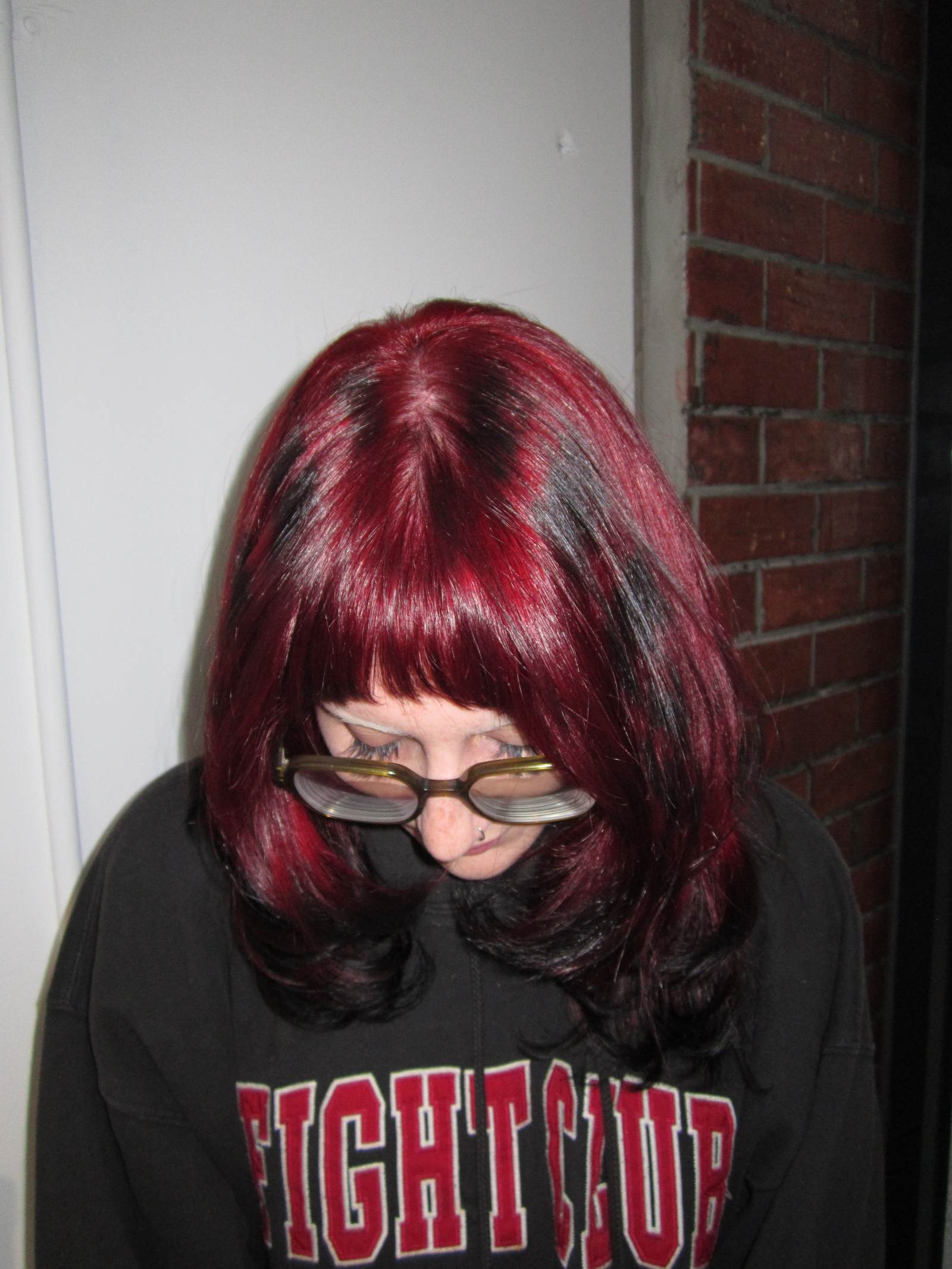 A stunning vibrant red hair transformation showing dimensional ruby tones and a high-shine finish at Assort Melbourne salon.