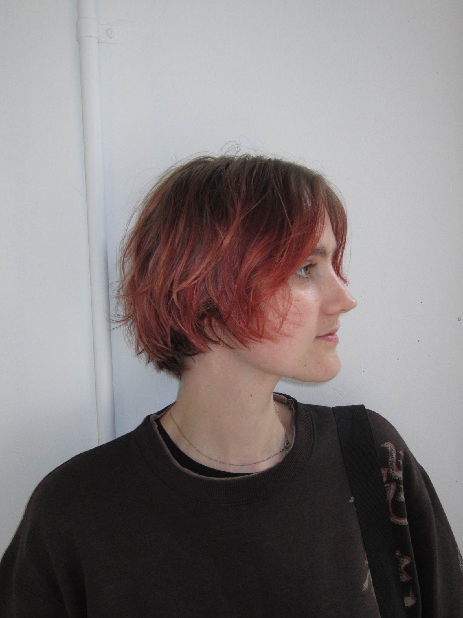 client at Assort Melbourne showcasing a short, layered haircut with face-framing movement and a high-shine finish using Evo products
