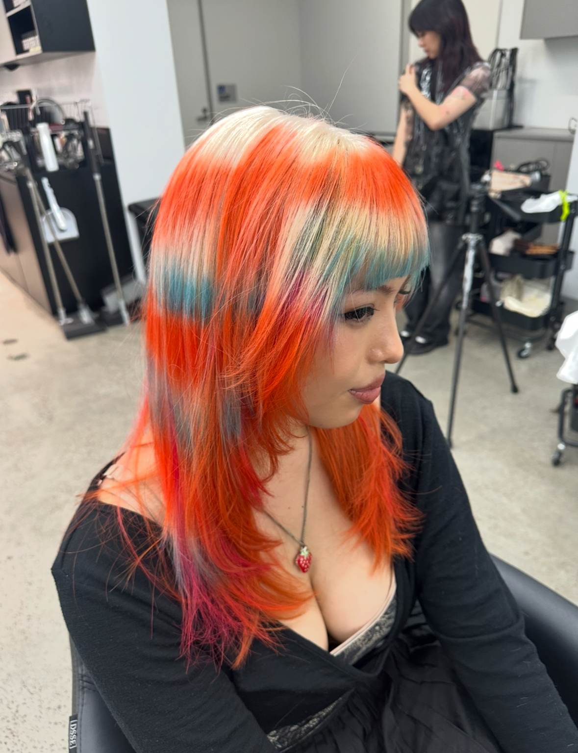 A client at with multi coloured hair, predominantly orange done professionally at Assort Melbourne
