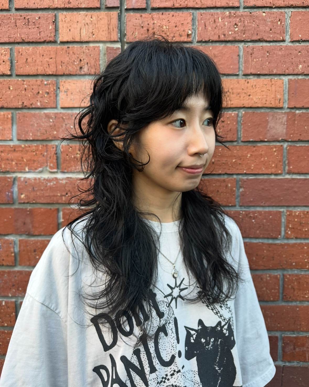 client at Assort Melbourne showcasing a long, layered haircut with face-framing movement and a high-shine finish using Evo products