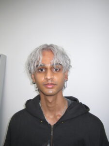 Before and after hair transformation at Assort Melbourne: Men's natural dark curly hair changed to a bright ashy white platinum with a trendy layered haircut.