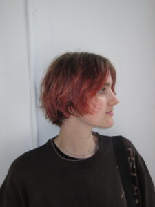 client at Assort Melbourne showcasing a short, layered haircut with face-framing movement and a high-shine finish using Evo products