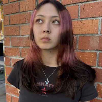 Close-up of a vibrant pink "Angel Halo" face-framing hair trend on long dark hair at Assort Melbourne.