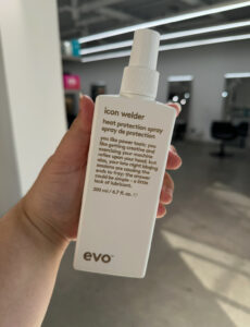 A bottle of EVO Icon Wielder, a premium heat protectant used at Assort Melbourne 