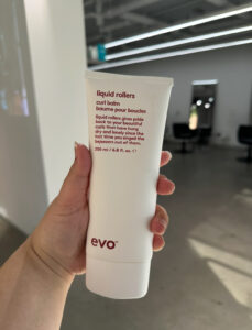 A bottle of EVO Liquid Rollers Curl Balm, a premium styling product used at Assort Melbourne to define natural curls and provide humidity resistance.