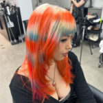A client at with multi coloured hair, predominantly orange done professionally at Assort Melbourne