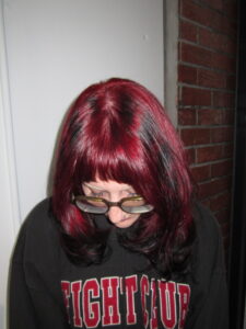 A stunning vibrant red hair transformation showing dimensional ruby tones and a high-shine finish at Assort Melbourne salon.