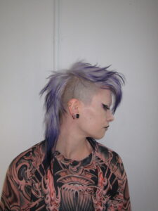 High-texture mohawk featuring a seamless color melt from a light lavender base to deep, rich purple tips, styled at Assort Melbourne.