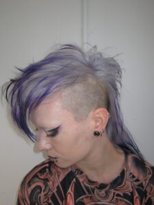 High-texture mohawk featuring a seamless color melt from a light lavender base to deep, rich purple tips, styled at Assort Melbourne.