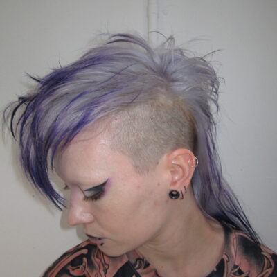 High-texture mohawk featuring a seamless color melt from a light lavender base to deep, rich purple tips, styled at Assort Melbourne.