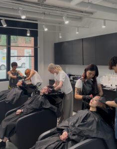 Hair Stylists at Assort Melbourne washing clients hair in shampoo basin