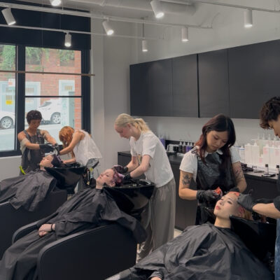 Hair Stylists at Assort Melbourne washing clients hair in shampoo basin