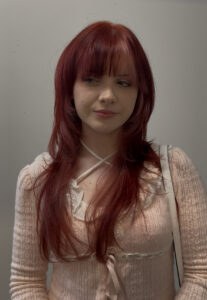 A stunning vibrant red hair transformation showing dimensional ruby tones and a high-shine finish at Assort Melbourne salon.