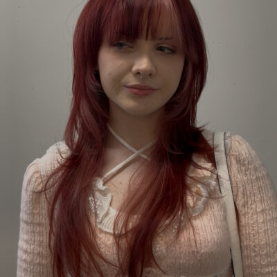 A stunning vibrant red hair transformation showing dimensional ruby tones and a high-shine finish at Assort Melbourne salon.